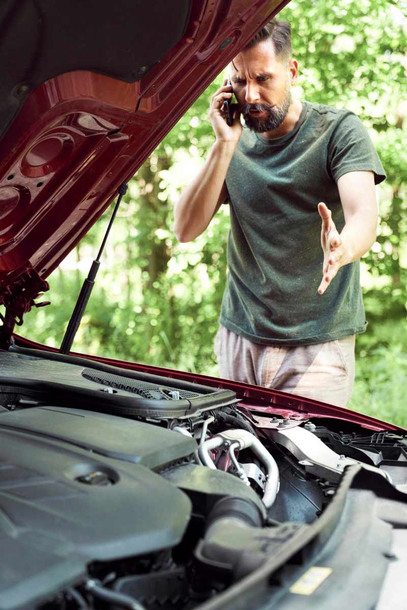 Junger Mann prüft Getriebeschaden bei Schrottauto Ankauf Grevenbroich